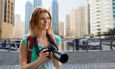 Canvas Print - woman with backpack and camera over dubai city