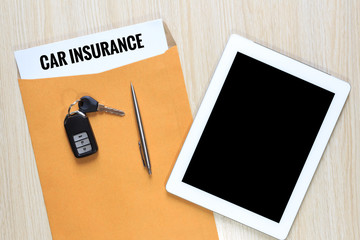 Wall Mural - Top view of Car insurance in envelope with car remote key and tablet