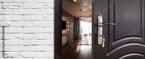 Fotografía Half open door of a modern living room closeup.