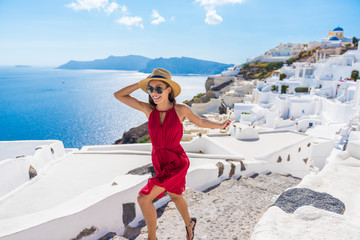 Fototapete - Travel Tourist Happy Woman Running Stairs Santorini, Greek Islands, Greece, Europe. Girl on summer vacation visiting famous tourist destination having fun smiling in Oia.