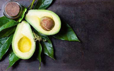 Avocado with leaves on black background. top view