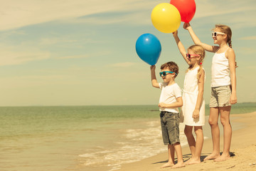 Wall Mural - Happy children playing on the beach at the day time.