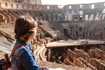 young girl with backpack exploring inside the colosseum (coliseum)