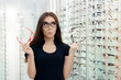 Woman Choosing Eyeglasses Frames in Optical Store
