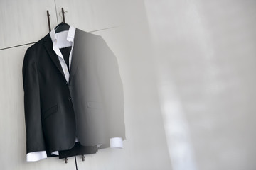 Black suit hanged to a wood closet in natural light