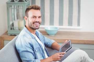 Wall Mural - Portrait of young man using tablet