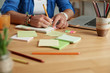 © DragonImages - Cropped image of creative woman writing ideas on stickers