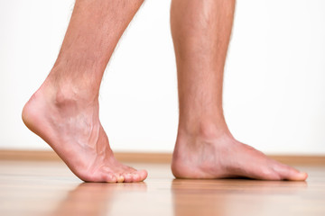 Pair of clean male feet without any illness making a step.