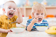 © Andrey Kuzmin - Funny little kids eating from plates in kindergarten