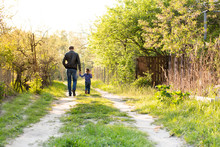 Dad And Daughter Walking On The Country Road