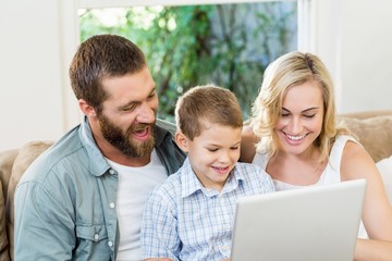 Wall Mural - Parents and son using laptop in living room