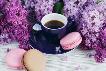 Wall Mural - Cup of black coffee, lilac flowers and sweet pastel french macar