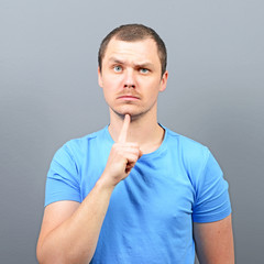 Wall Mural - Portrait of attractive young man thinking about something agains