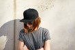 Female model wearing a black blank cap and sunglasses looking away. Portrait of a young beautiful girl with cap
