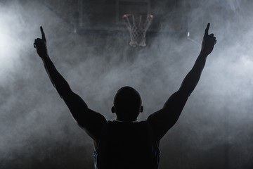 rear view of a basketball player with his arms in the air