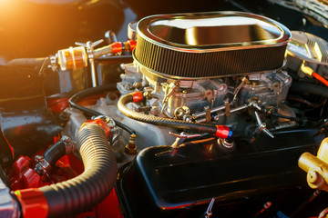 Car engine under hood at sunset