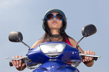 Woman Sitting On A Scooter On A Blue Background