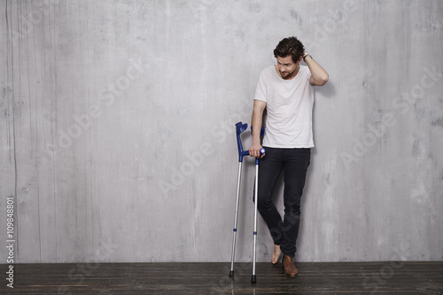 Cuadros en Lienzo Young man in studio with crutches