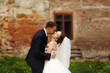 © IVASHstudio - Bride enjoys a tender kiss in groom's hands