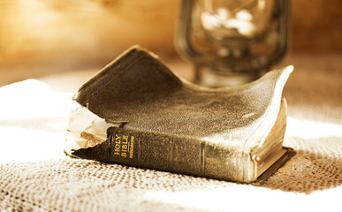 ancient and torn bible illuminated by a sunbeam