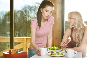 Two Female Friends Enjoying Breakfast At Home Together