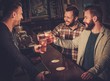 © Nejron Photo - Cheerful old friends having fun and drinking draft beer at bar counter in pub.