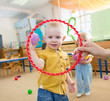 © Andrey Kuzmin - Happy kid playing with ball and ring in kindergarten