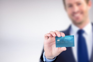 Wall Mural - Composite image of happy businessman showing a creditcard