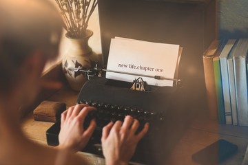 Canvas Print - New life chapter one against young woman using typewriter