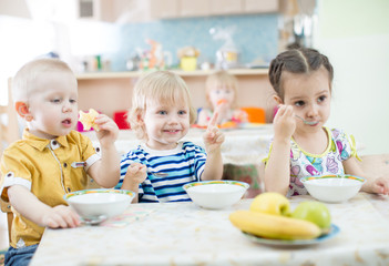 Funny kids eating in kindergarten