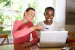 © mimagephotos - Young couple using laptop together at home