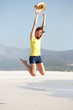 © mimagephotos - Excited young woman jumping on the beach