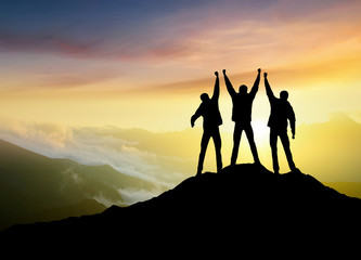 Wall Mural - silhouettes of team on mountain peak. sport and active life concept..