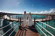 © Dmitry Yakunin - Gorgerous just married couple walking to villa by bridge after w