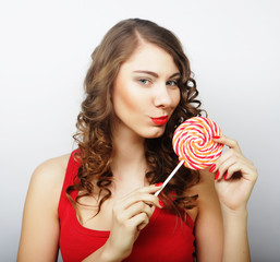 portrait of a smiling cute girl covering her lips with lollipop