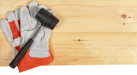 Wall Mural - Hammer and gloves wrench on wooden background