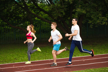 Running athletes at stadium.