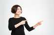 © Drobot Dean - Smiling woman pointing fingers away
