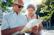 © Jacob Lund - Elderly couple sitting outdoors on a bench and using city map