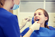 © Syda Productions - female dentist checking patient girl teeth