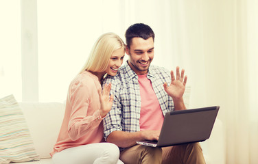 Canvas Print - smiling happy couple with laptop computer at home