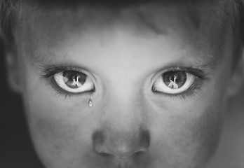 Little boy's eyes close up with a tear