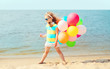 © rohappy - Little girl child playing on beach with colorful balloons near s