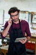 © WavebreakmediaMicro - Carpenter on the phone and holding his tablet