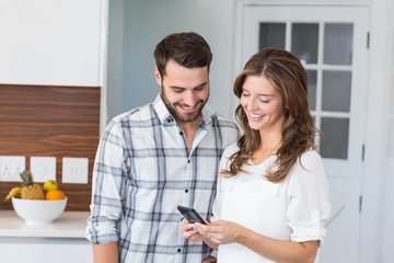 Wall Mural - Happy couple looking in mobile phone