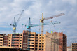 © mikola249 - Construction site with cranes on sky background