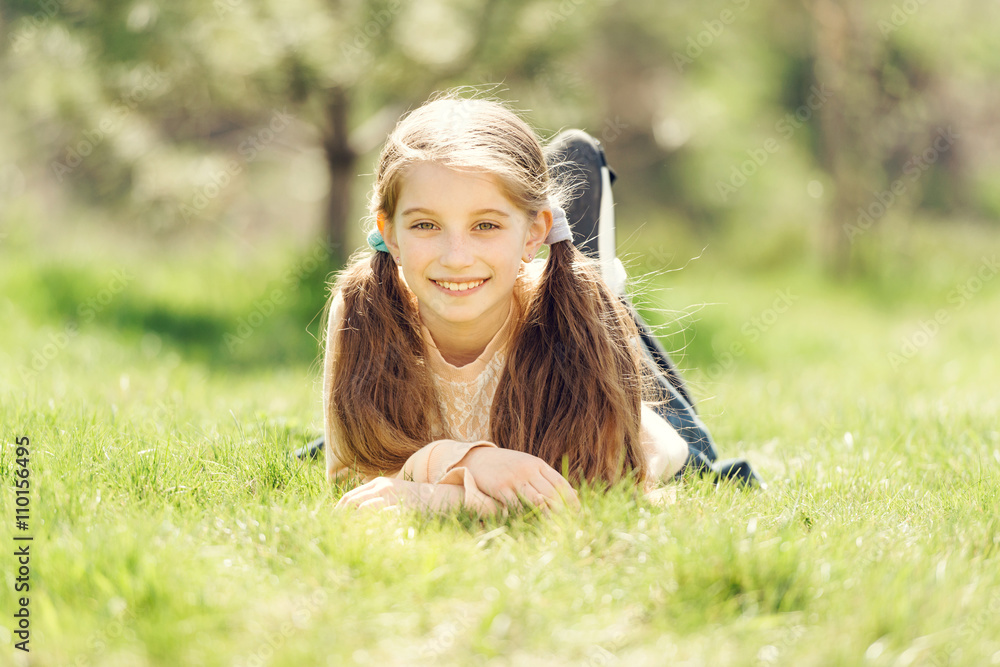 cute smiling little girl lying on the grass Stock Photo | Adobe Stock