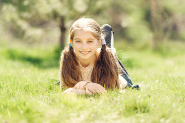 cute smiling little girl lying on the grass