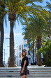 Young girl standing by palm trees