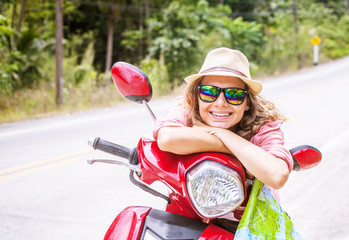 Wall Mural - Beautiful young woman with map in hand and a motorbike on the ro